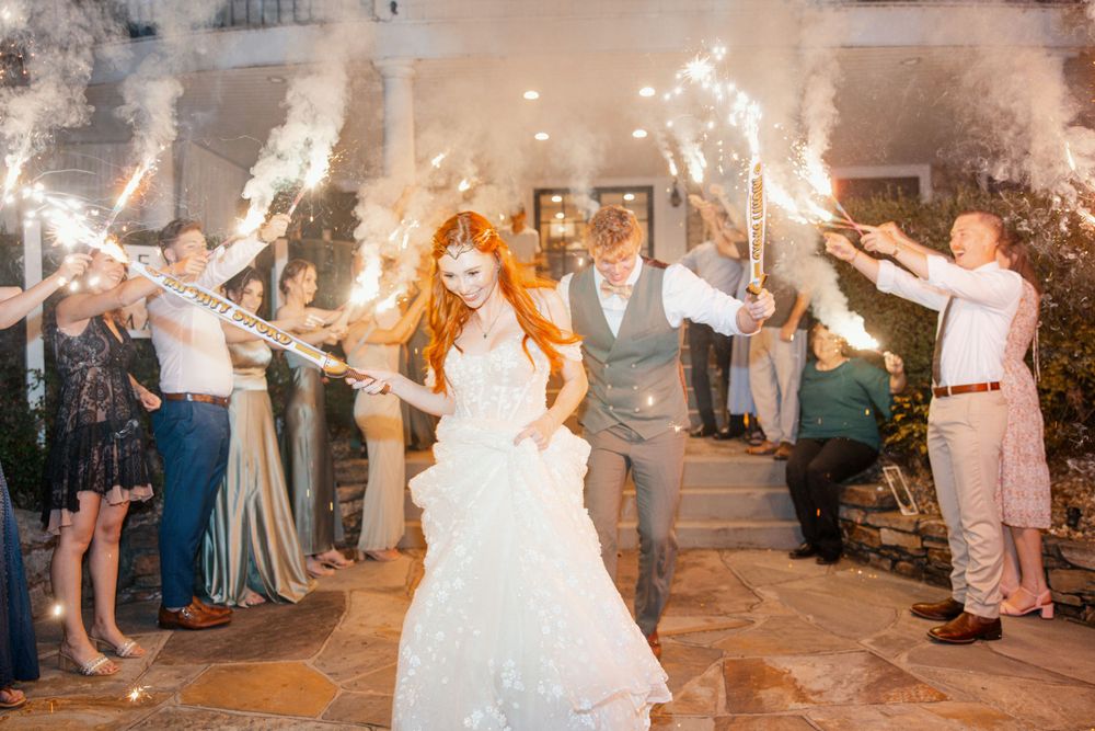 Wedding couple celebrates under sparklers during their evening reception exit.