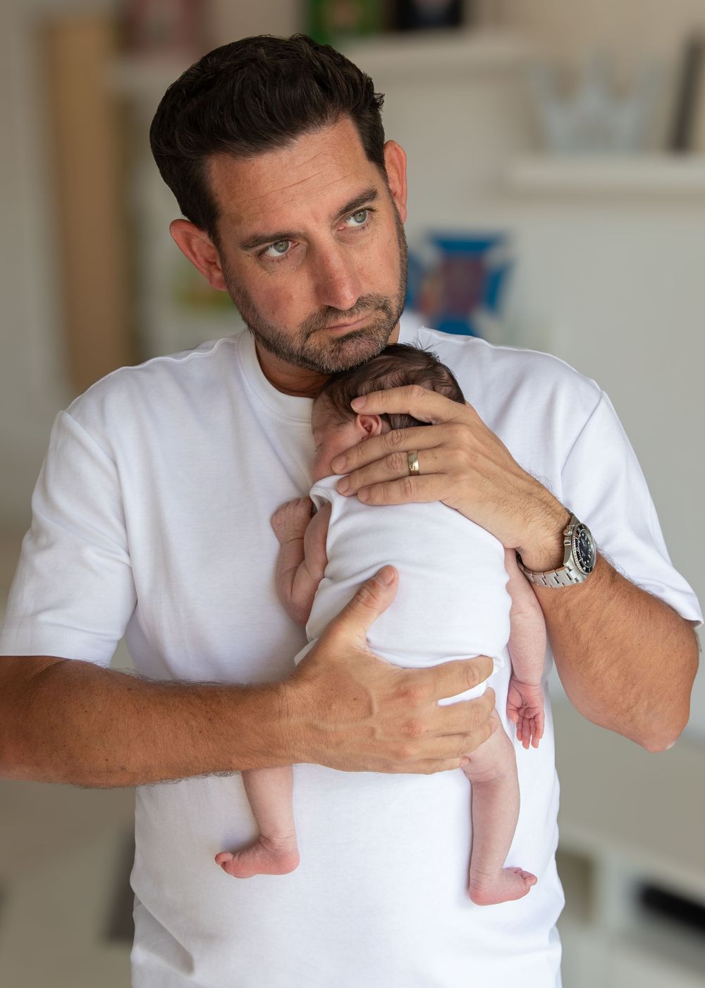 Father holding newborn in Dubai lifestyle at-home baby photoshoot in dubai