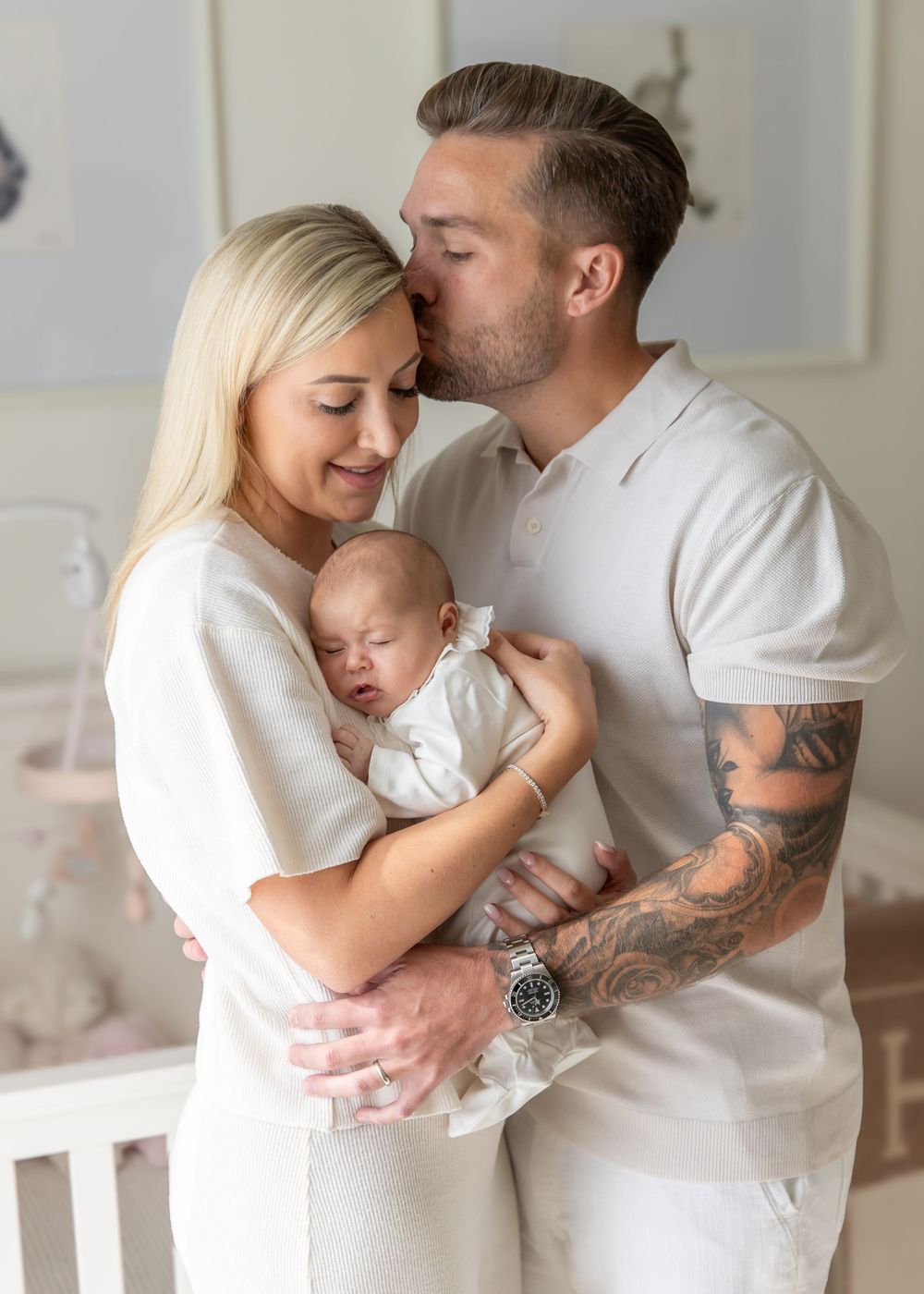Parents cuddling newborn baby in baby's nursery at-home during natural lifestyle newborn photoshoot