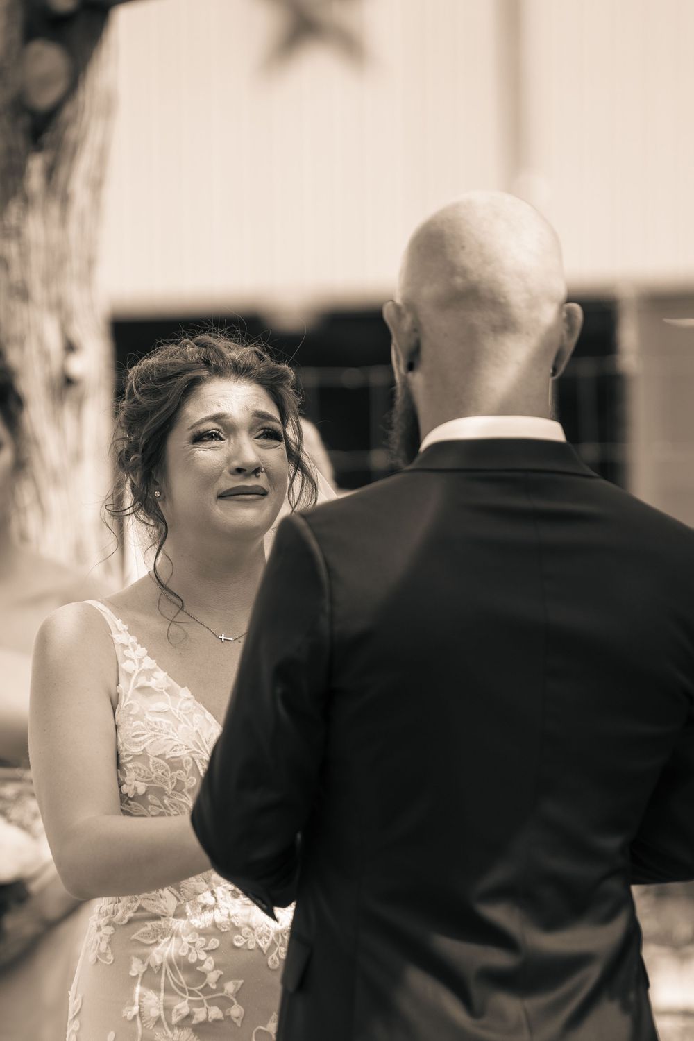 A candid black and white wedding photo showing tender moments between the couple during their celebration.