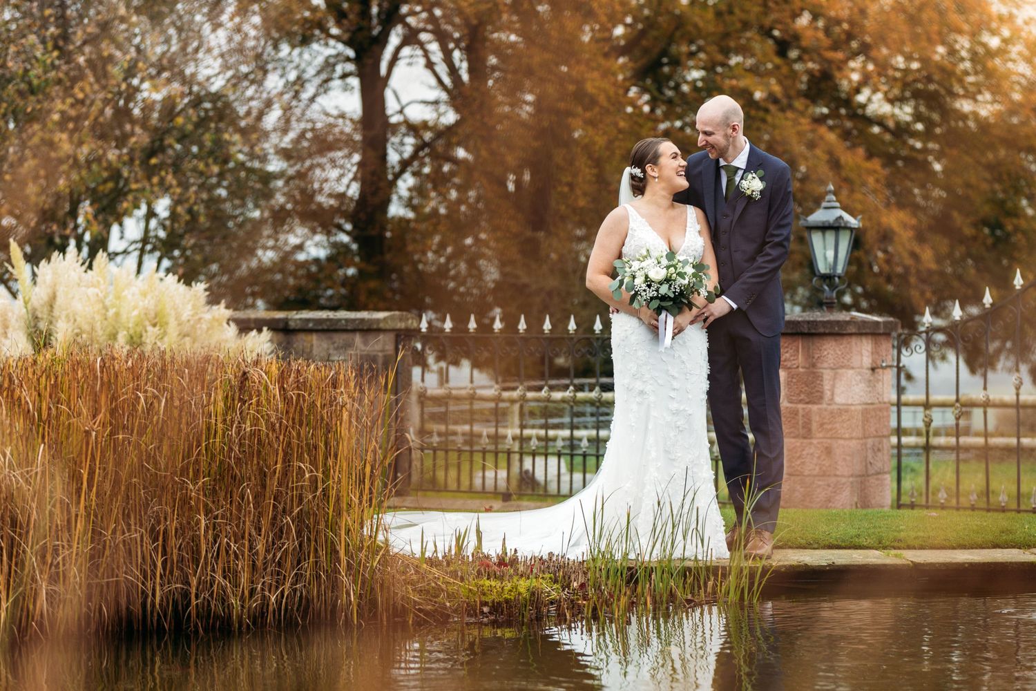Heaton House Farm wedding, with couple posing near pond.
