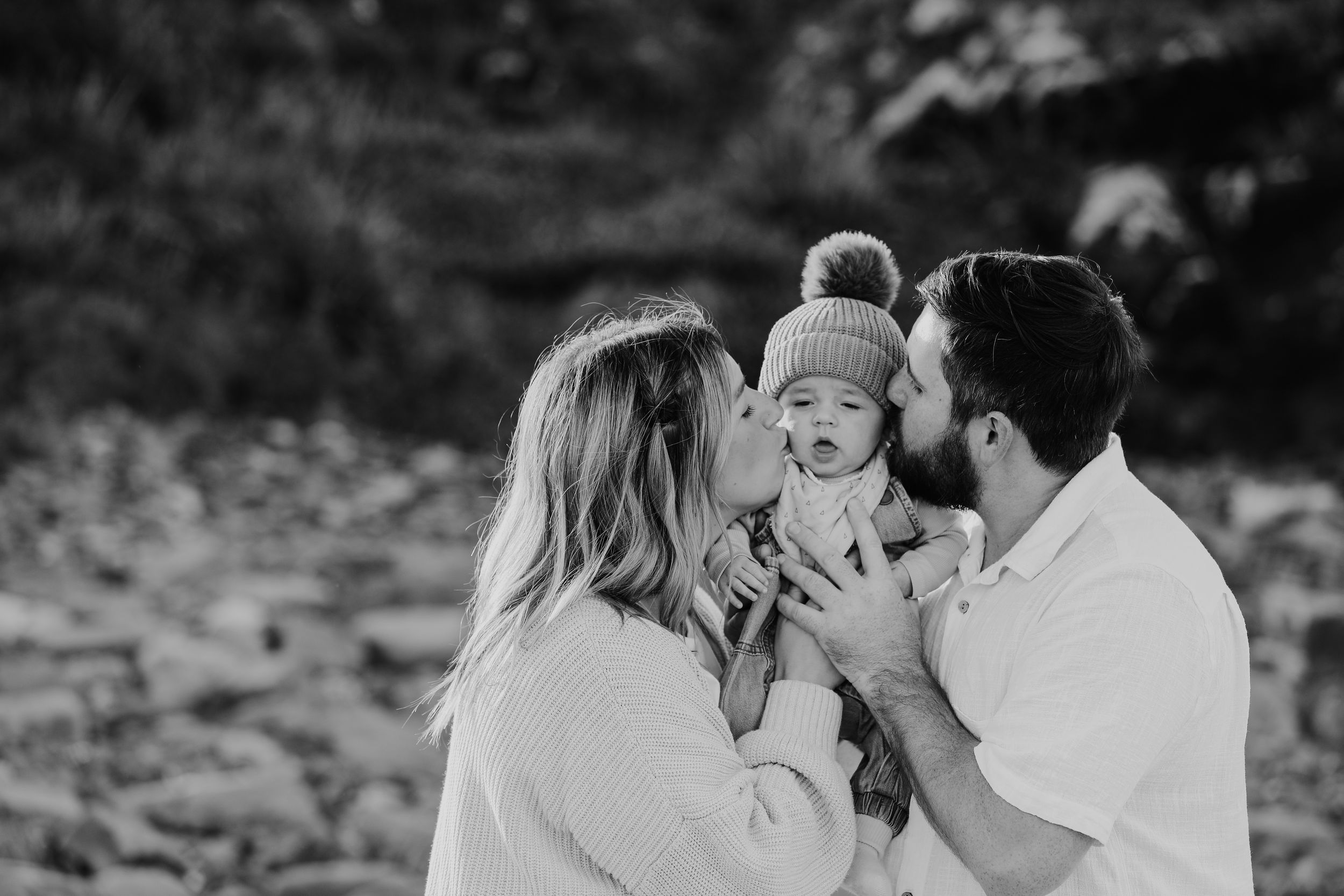 Black and white candid moments of family embracing outdoors.