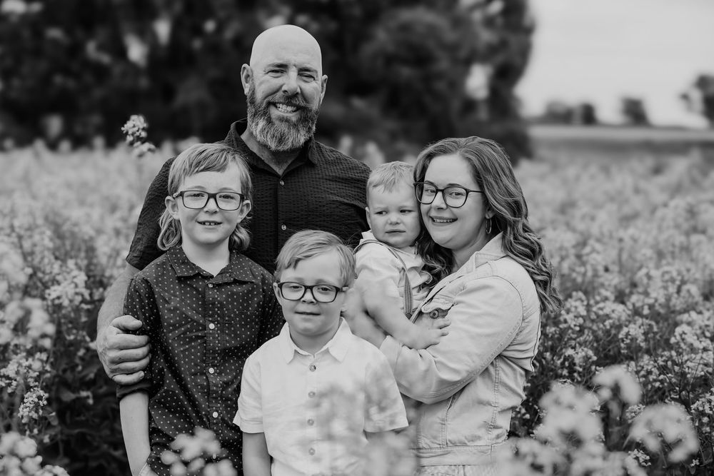 Black and white candid portraits of a family enjoying time together outdoors.