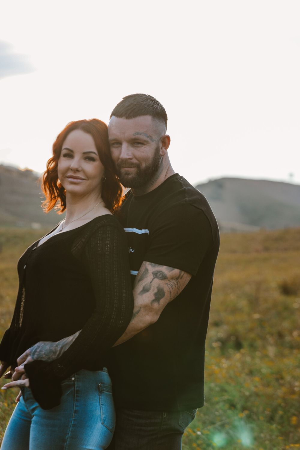 Couple sharing intimate moment while standing in golden sunlight.