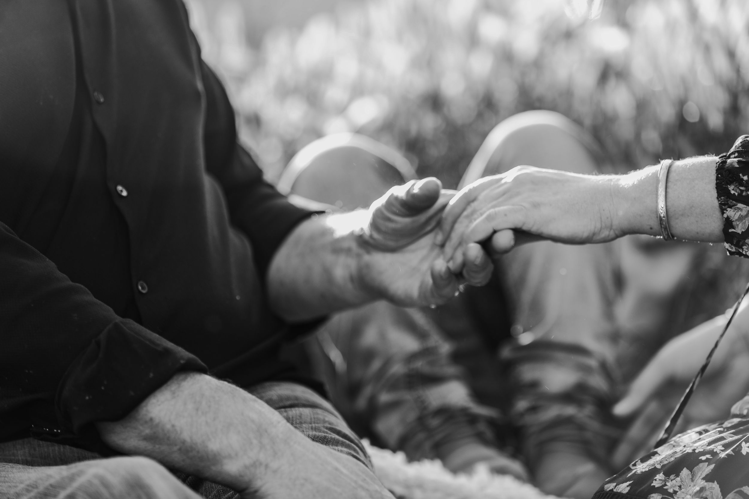 Black and white portrait of embrace in blooming field.