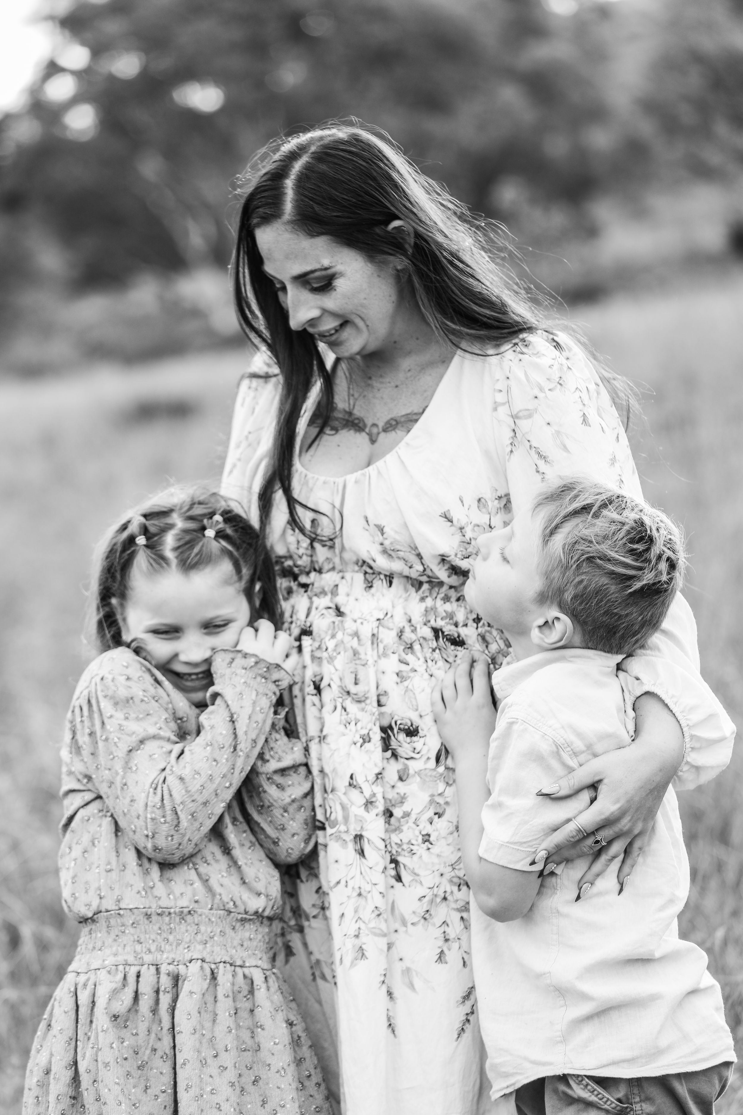 Black and white portrait of family sharing playful moment outdoors.