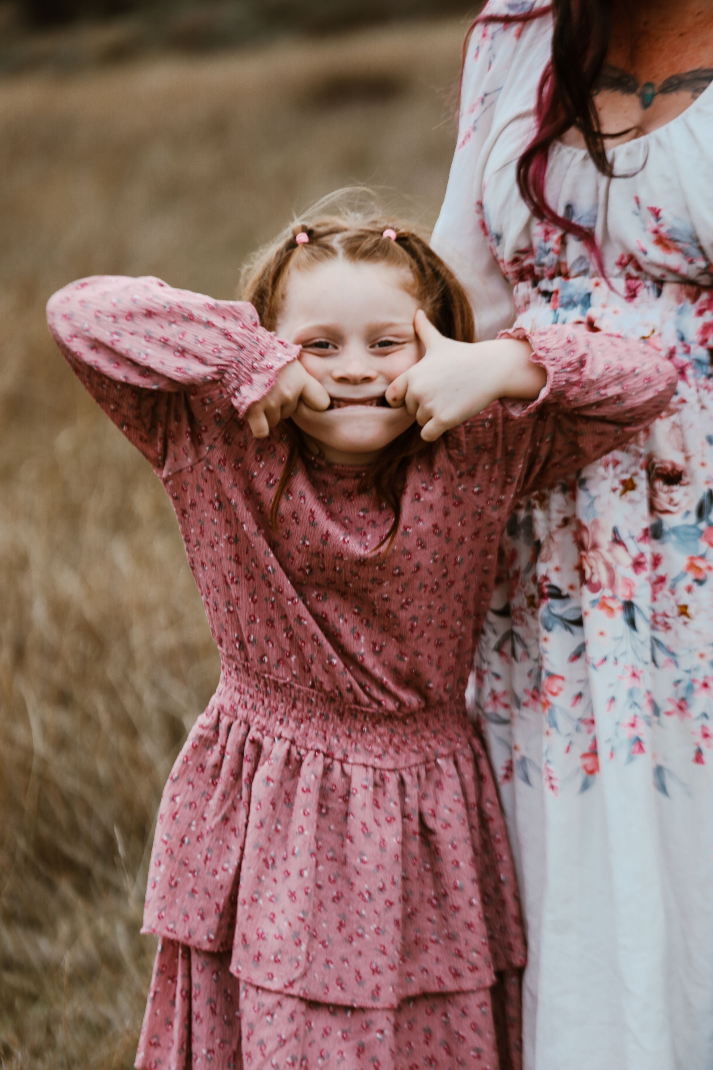 Candid family moment with children in floral dresses playing peek-a-boo.