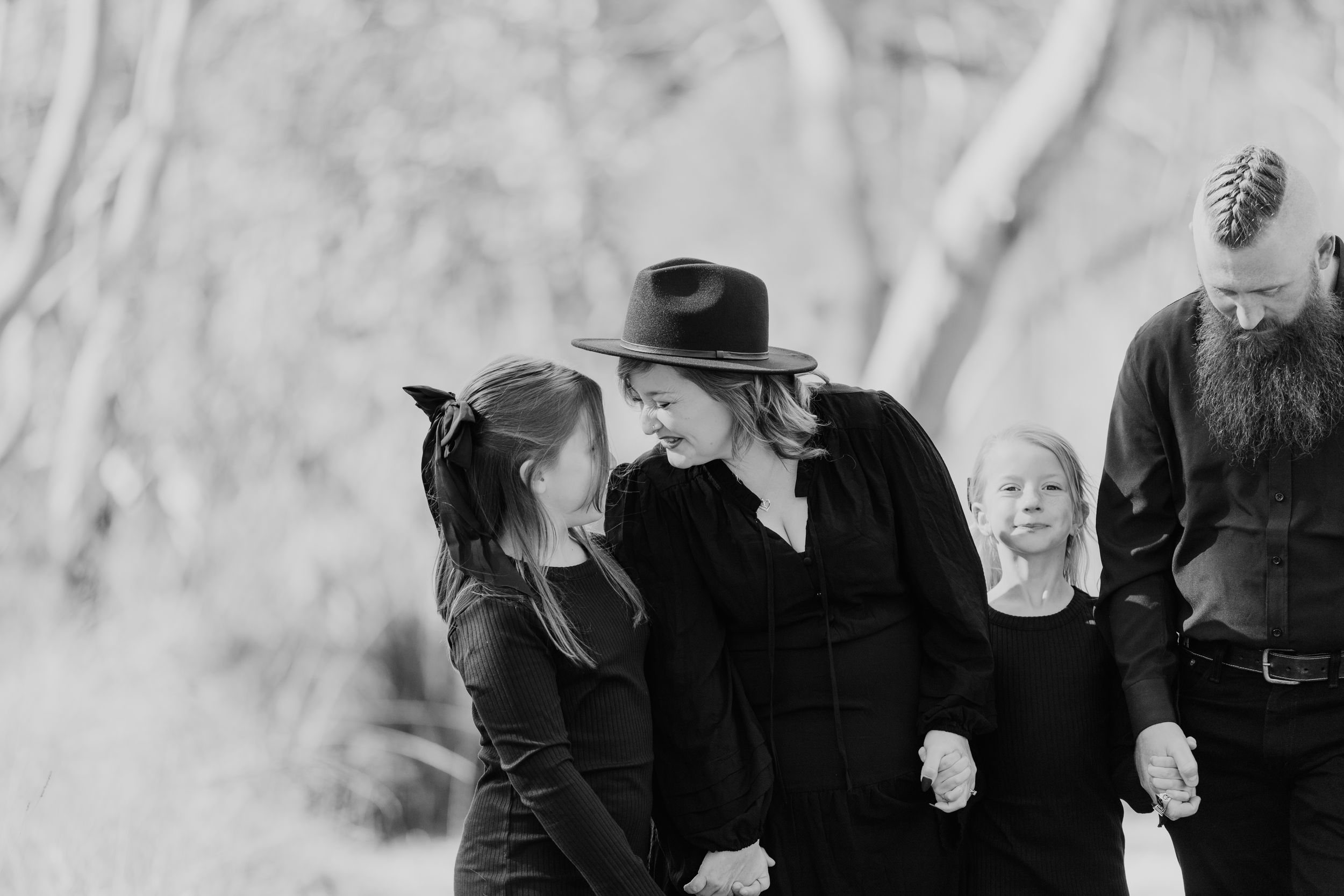 Group of people in black attire gathered outdoors for a monochrome photo session.