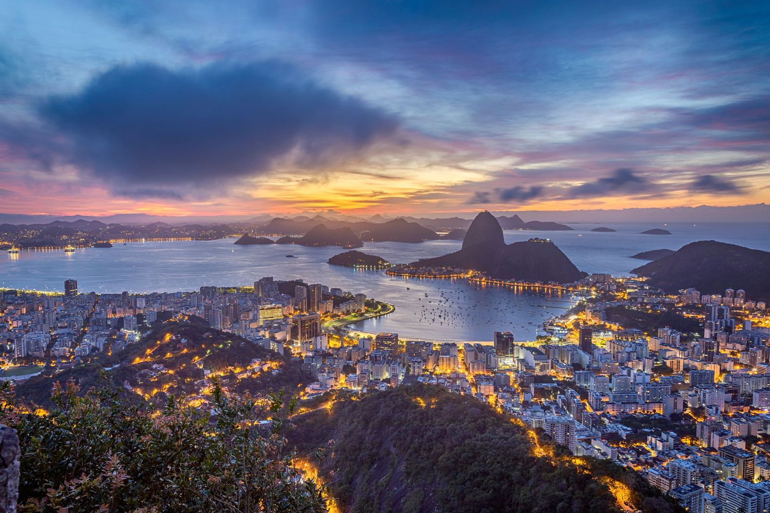 Stunning twilight cityscape of Rio de Janeiro with Sugarloaf Mountain and glowing lights.