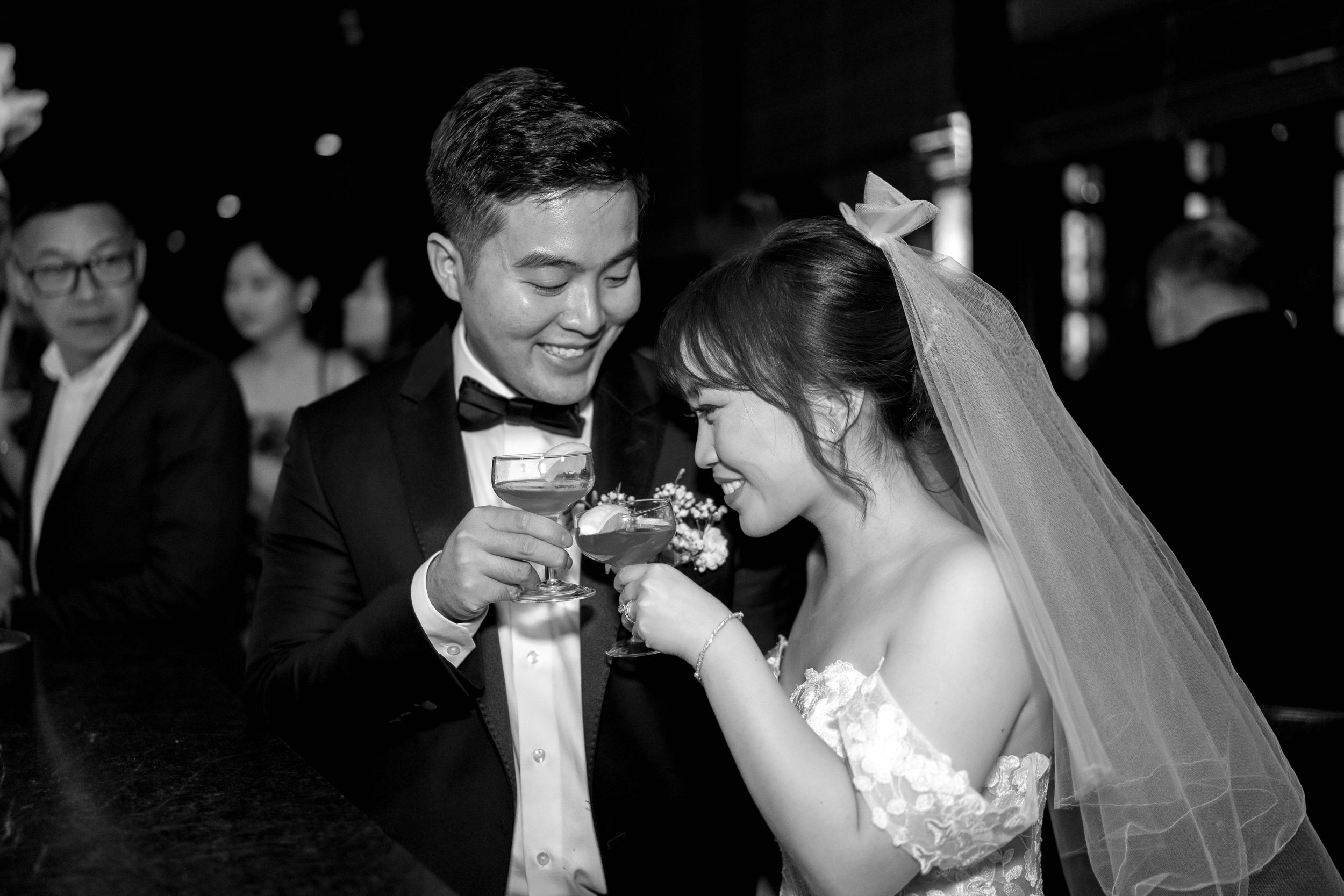Wedding couple sharing a playful toast moment at their reception celebration.