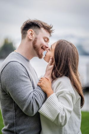 A couple in casual winter attire share intimate moments outdoors in a series of romantic poses.