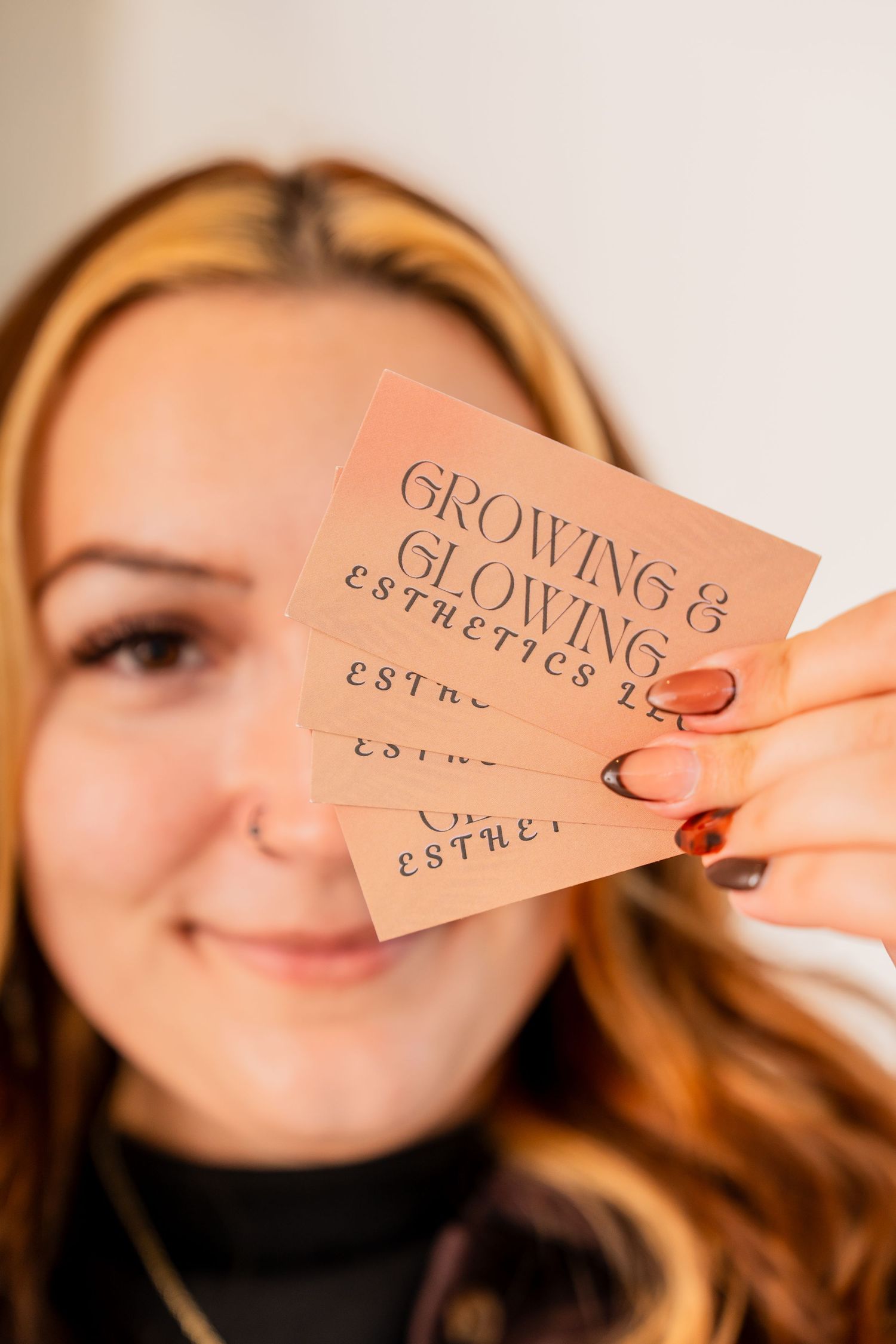 A sequence of photos showing someone holding up small orange paper tags with text against a light background.