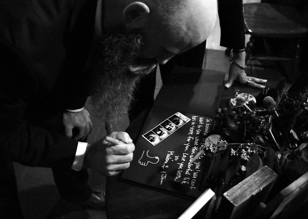 Photograph of a guest signing a book by wedding photographer William Wayland