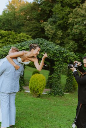 A joyful scene at an outdoor wedding with a photographer capturing moments in a garden setting.