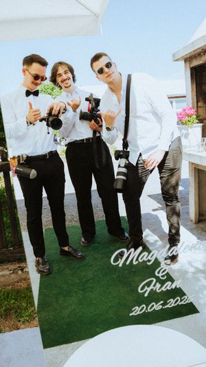 Three photographers in white shirts and sunglasses pose with cameras at Magdalena and Franz wedding on 20.06.2020.