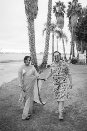 A playful sequence of black and white photos showing two people posing and dancing together among palm trees outdoors.