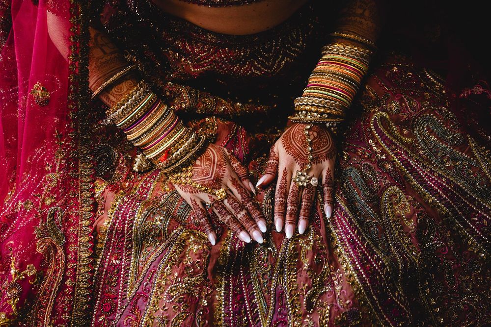 A traditional Indian wedding ceremony with vibrant red and gold decor and ornate bridal jewelry on display.