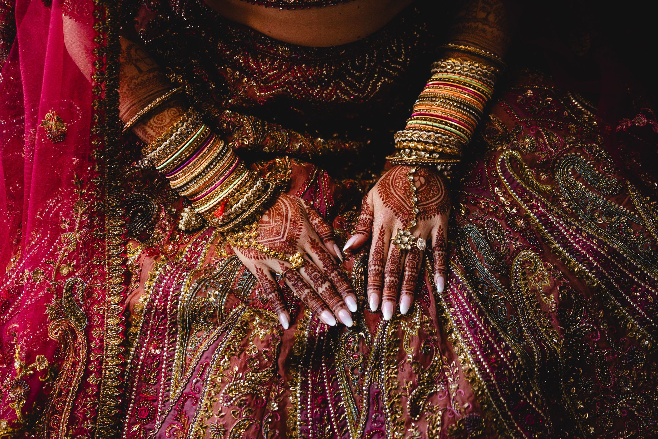 A traditional Indian wedding ceremony with vibrant red and gold decor and ornate bridal jewelry on display.