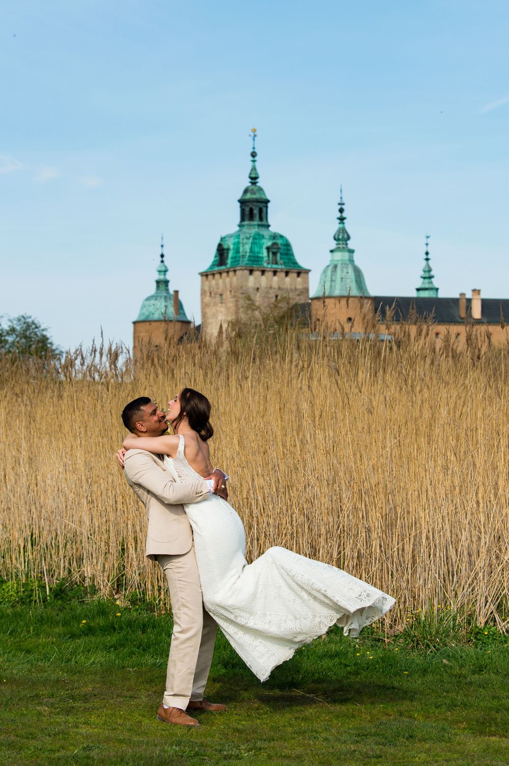 Brudgum lyfter brud framför Kalmar slott