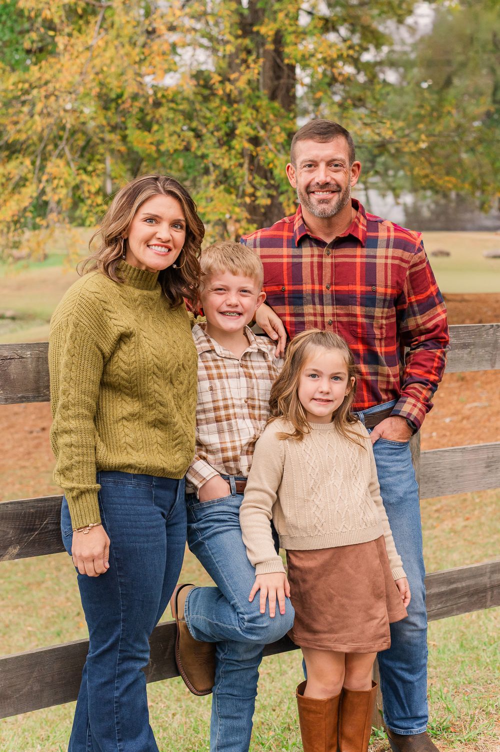 Family of four posing in front of wood gate, Senoia, GA