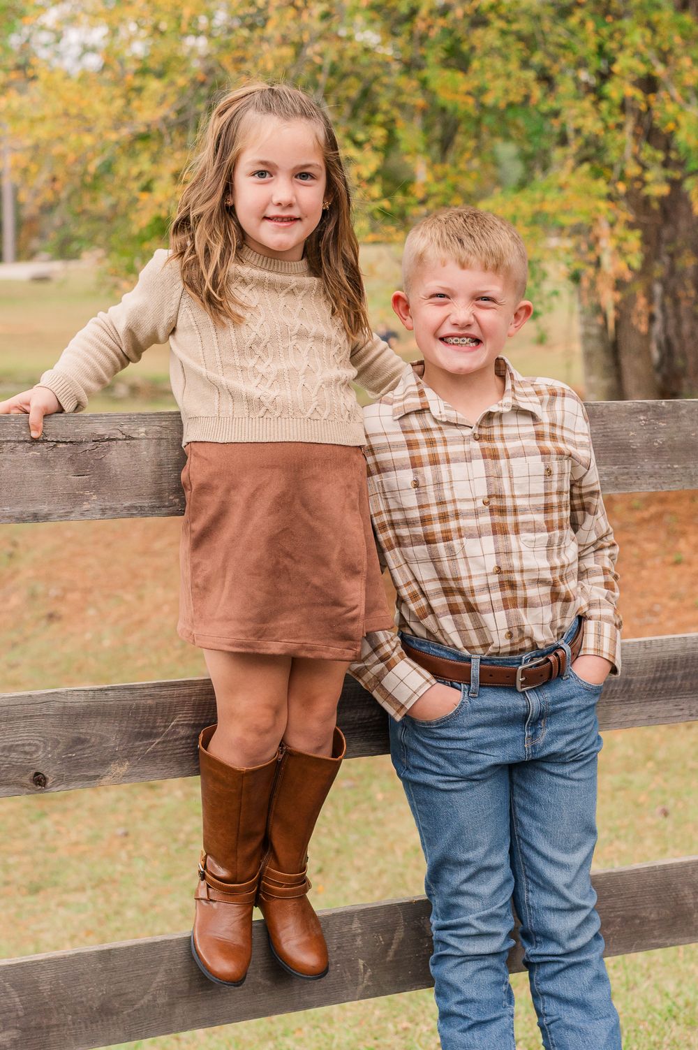 Boy and girl posing in front of wood gate, Senoia, GA