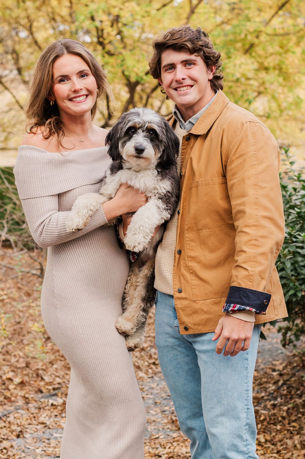 Couple posing by fall foliage with dog in Fayetteville, GA