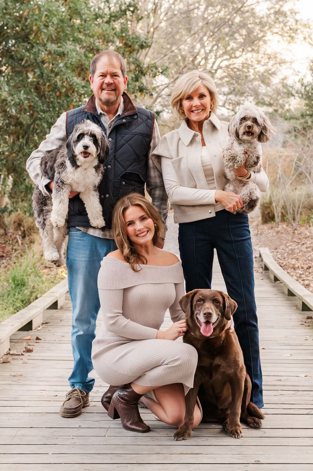 Family of three and three dogs posing on a wooden bridge, Fayetteville, GA
