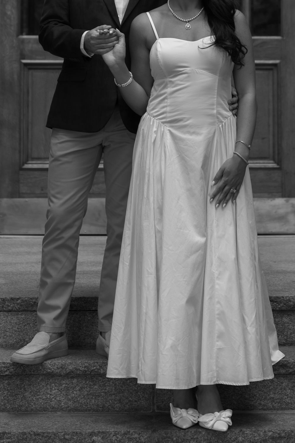 Close-up shot of formal attire and shoes on sidewalk.