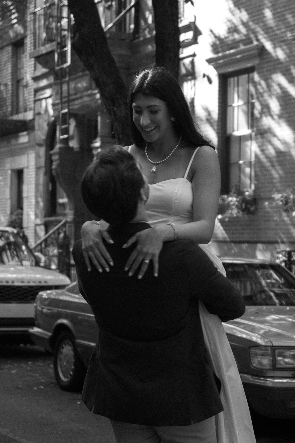 A couple embraces on a city street in a sequence of black and white photos.