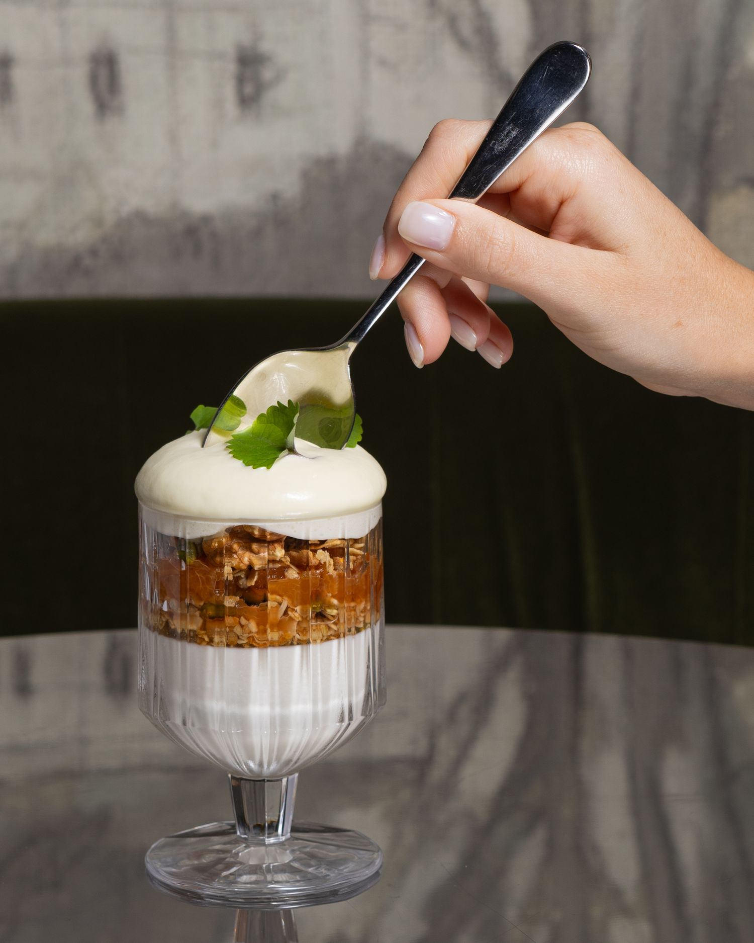 A series of six photos showing progressive steps of garnishing a cold creamy dessert drink with whipped cream and a leaf.