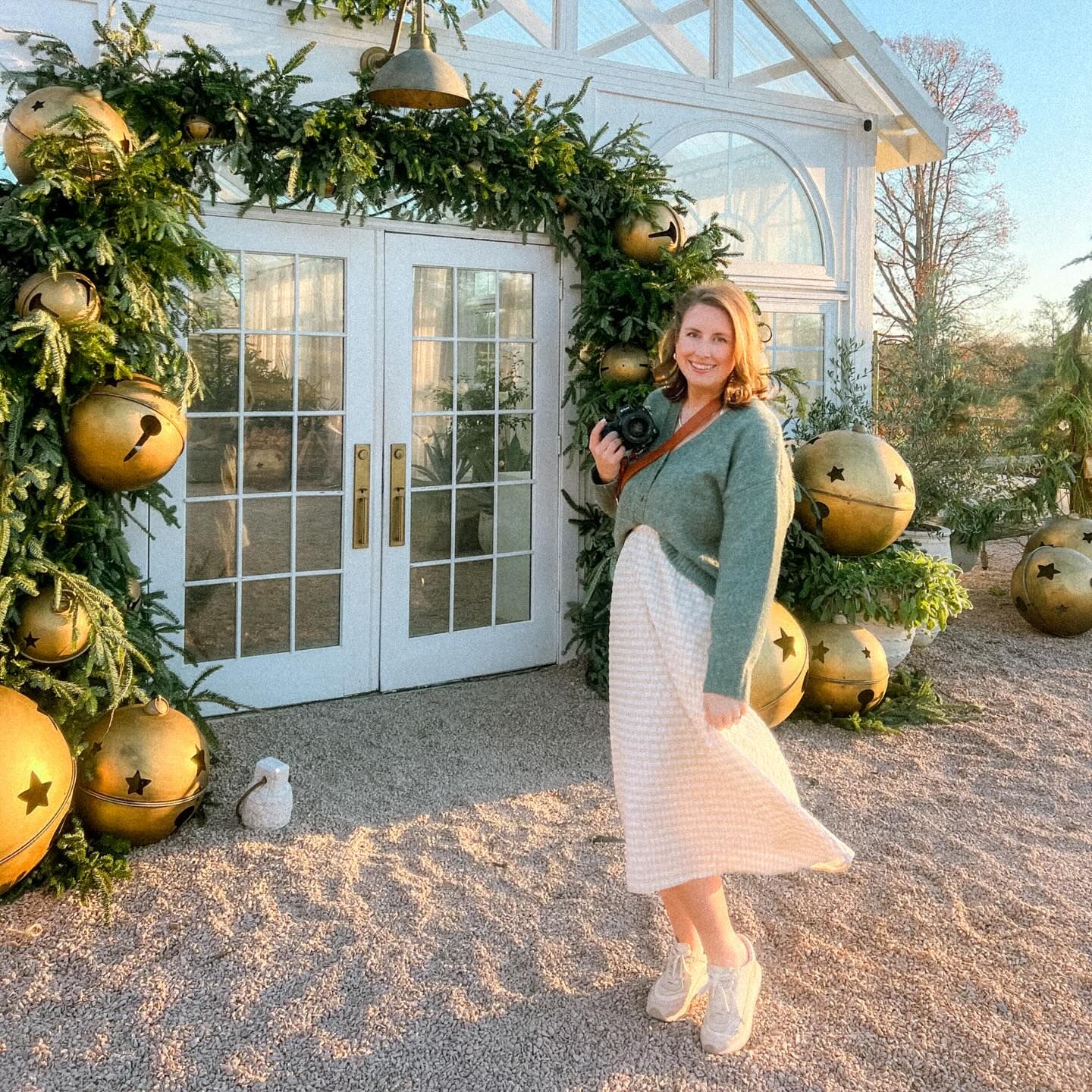 Holiday scene with festive gold ornaments and greenery arch framing French doors.