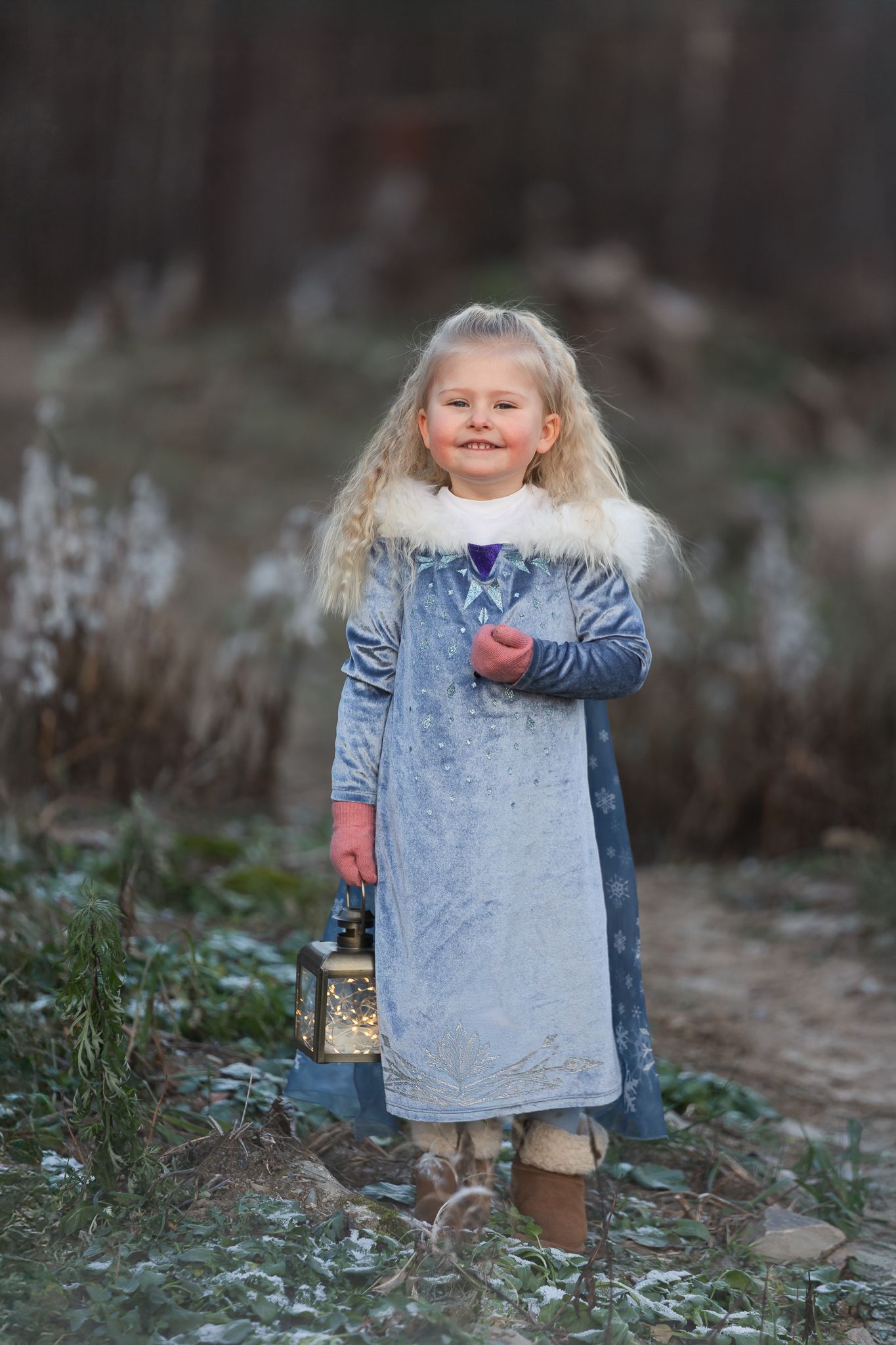 A small child in a blue dress plays outdoors in a candid sequence of playful movements.