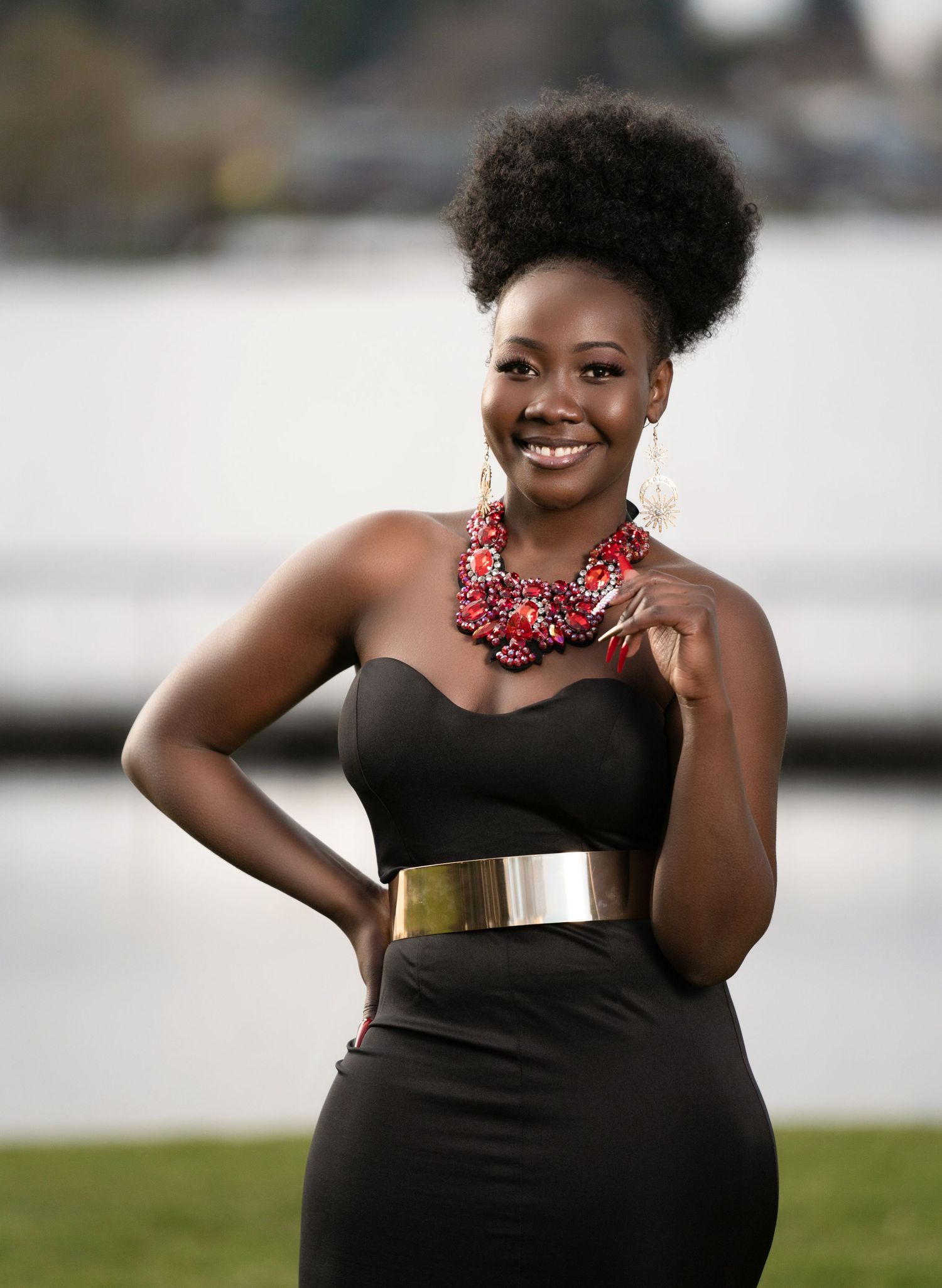 Stunning black dress with gold belt and coral statement necklace.