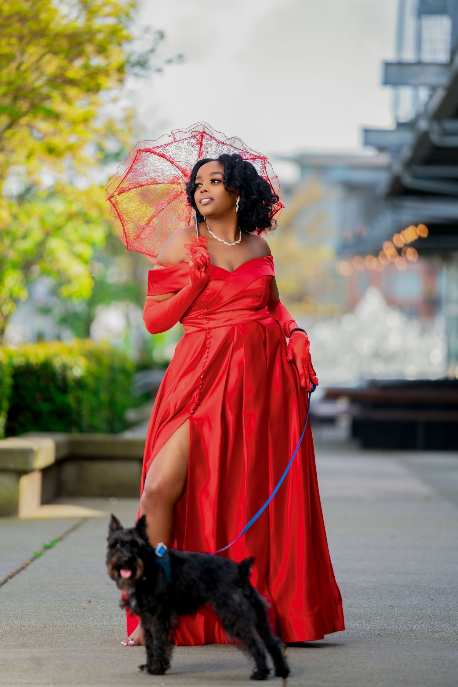 Red formal gown and umbrella evening photoshoot with black dog.