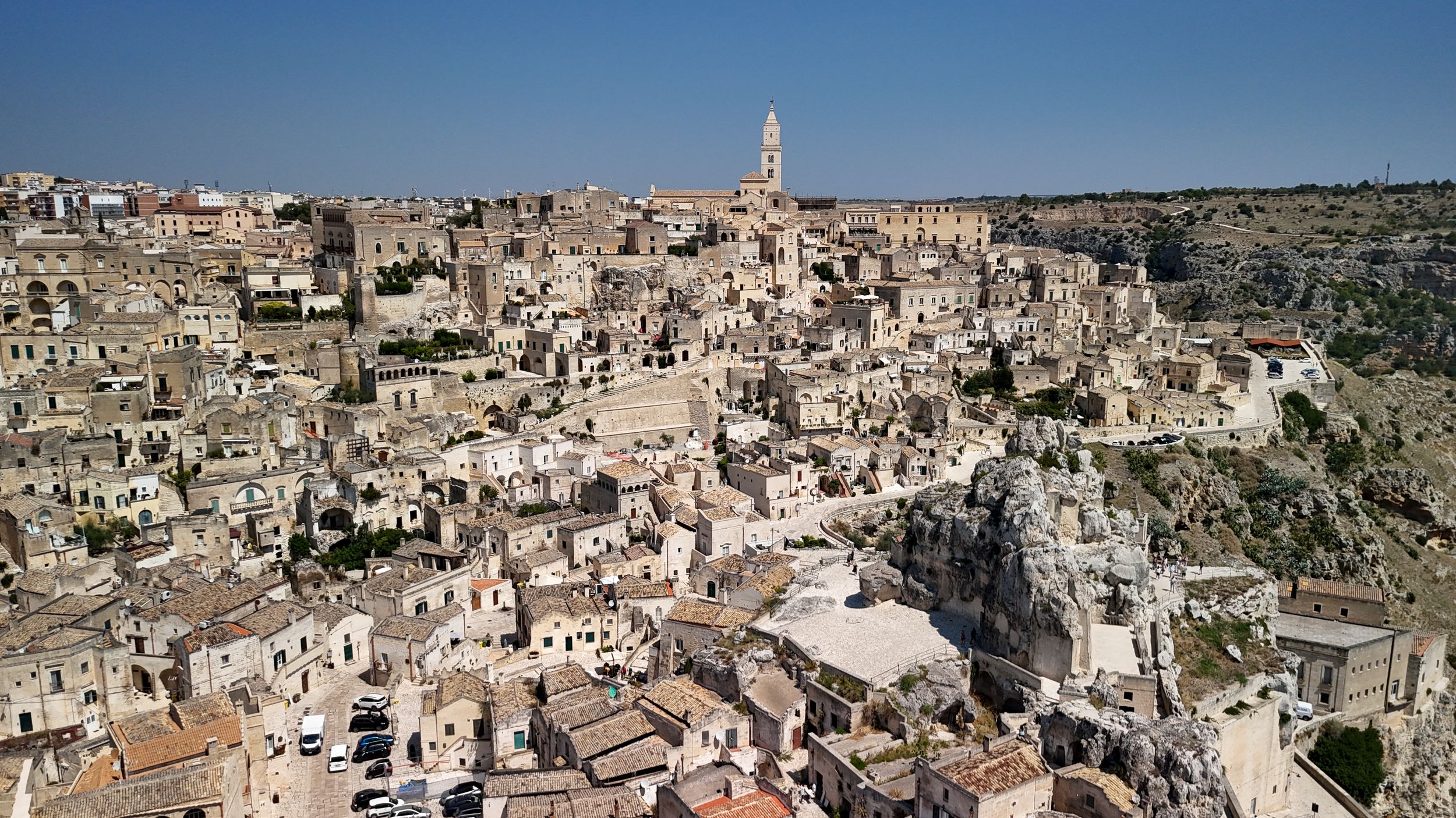 Panoramic view of ancient stone buildings and narrow streets in Matera's historic Sassi district in southern Italy.