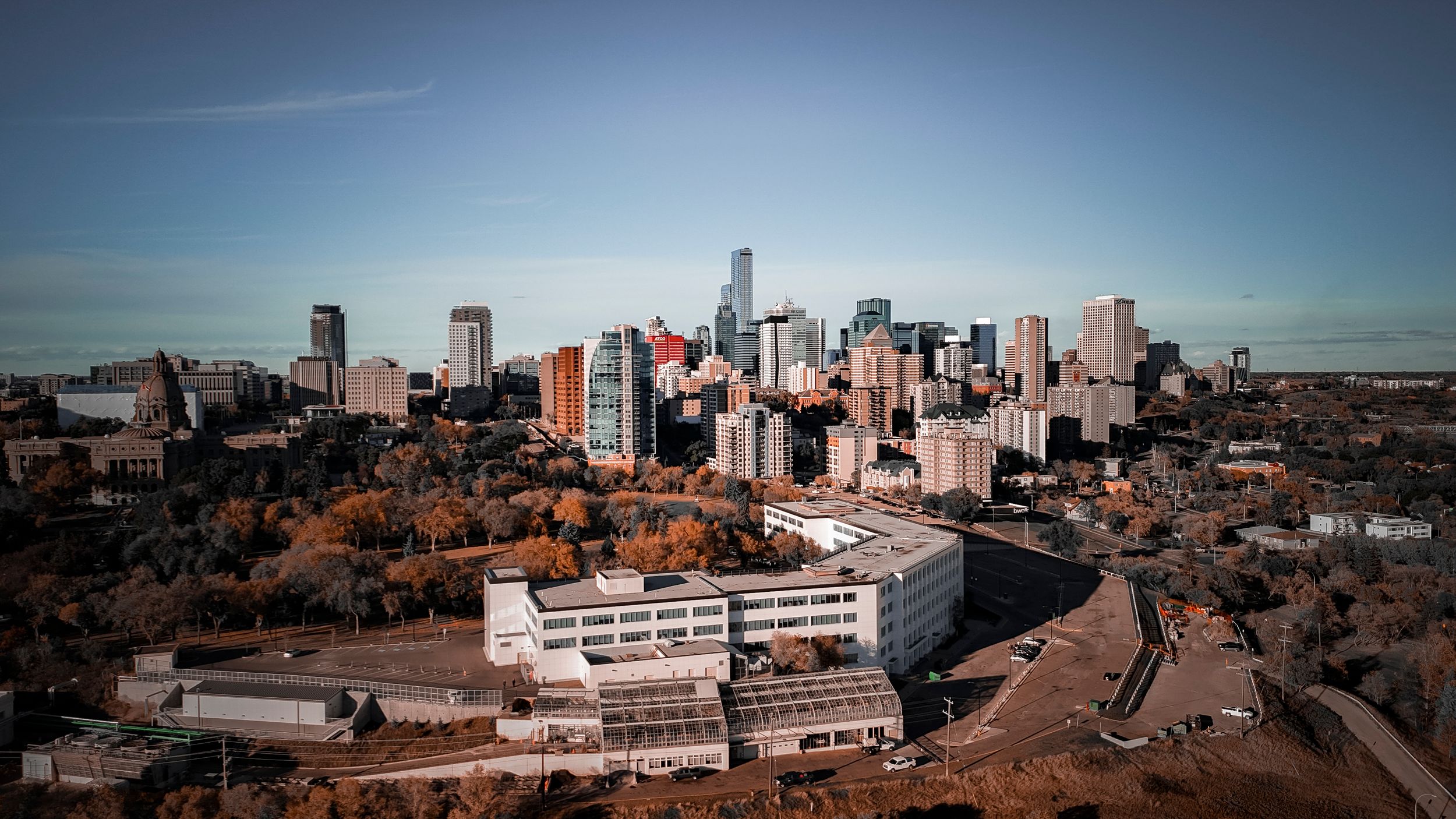 A panoramic aerial view of a city skyline with modern buildings and residential areas stretching to the horizon.
