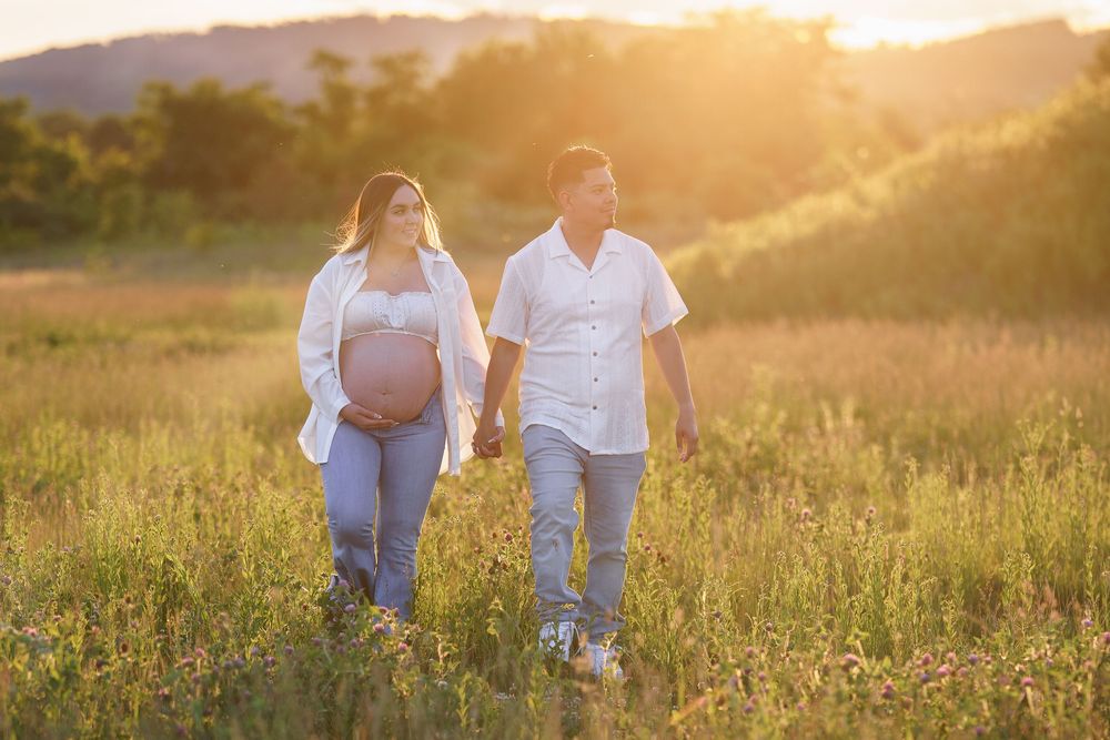 Couple walking hand in hand, maternity session in a field in Frederick, MD