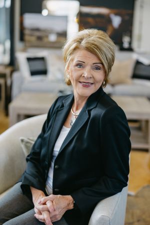 Professional in business attire seated in modern office setting.