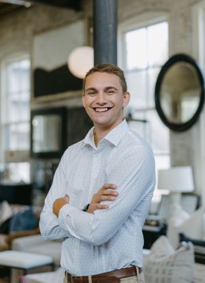 Professional portrait in a modern office interior with rustic decor and natural lighting.