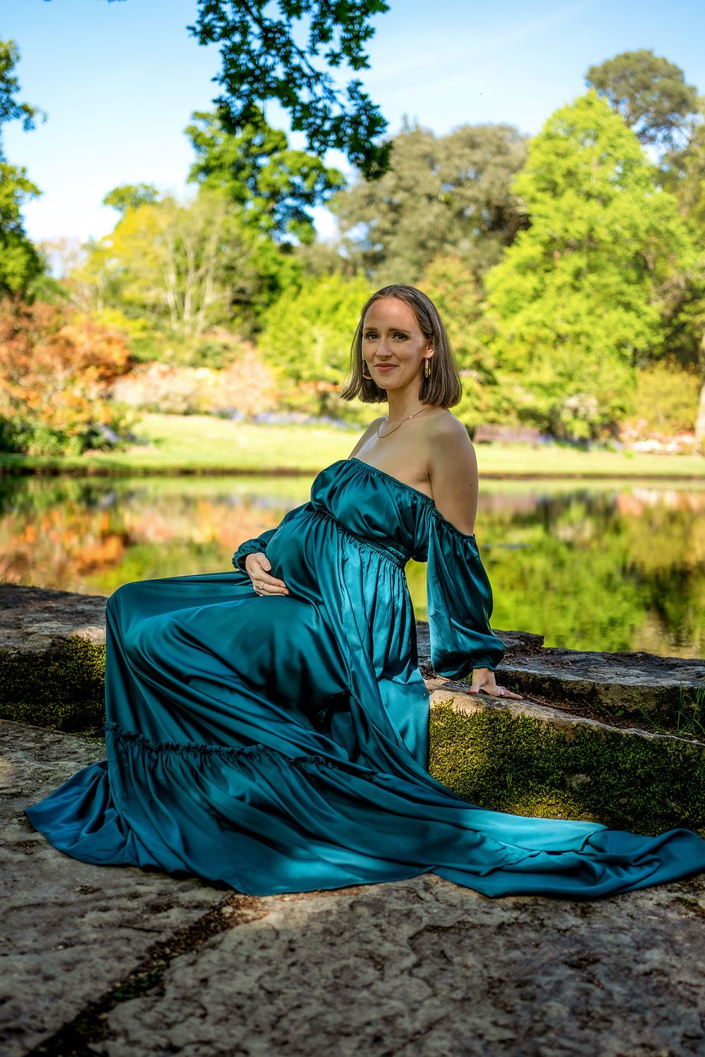Pregnant woman in emerald gown at Exbury Gardens, New Forest, Hampshire.