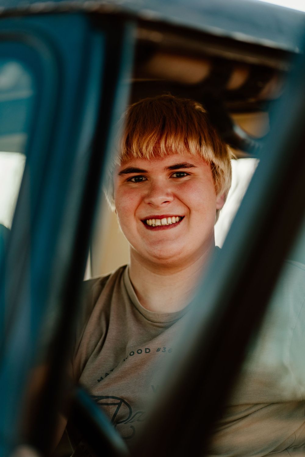 Through-window portrait with natural lighting and warm tones.