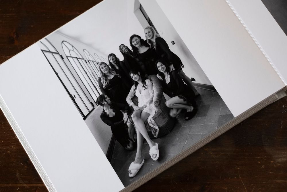 A black and white photograph of a group posing together on stairs in casual attire.