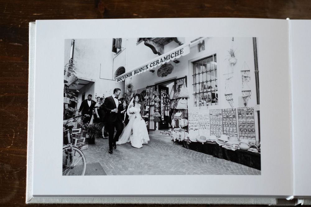 Black and white wedding photographs displayed in a vintage photo album showing various moments from a ceremony and reception.