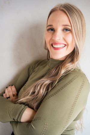 Person in olive green sweater poses against white background with natural expressions.