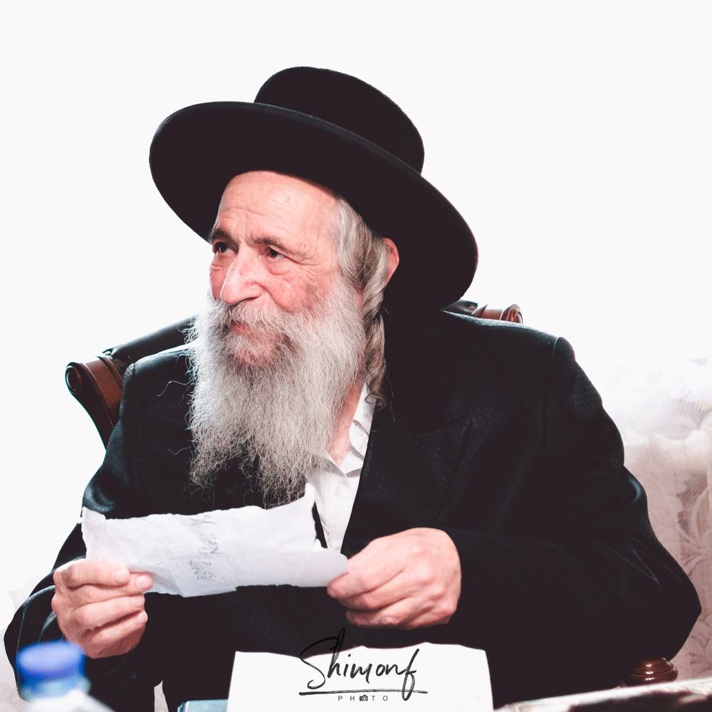A person in traditional black attire and hat writing with a pen at a desk in multiple similar views.