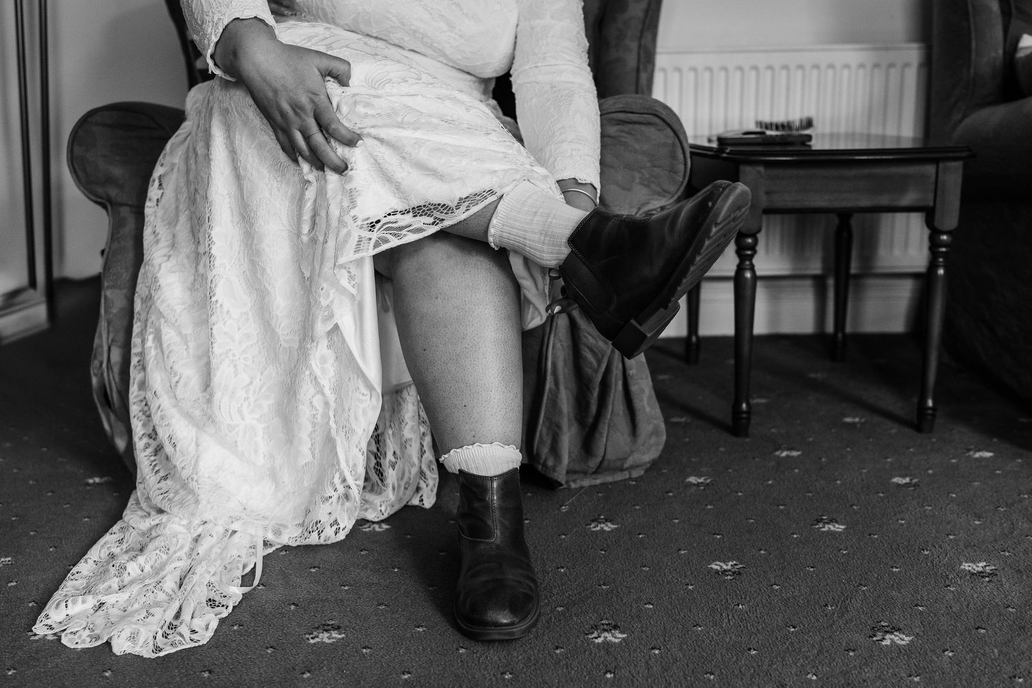Black and white photo series showing details of a bride and groom's shoes and wedding dress during a ceremony.