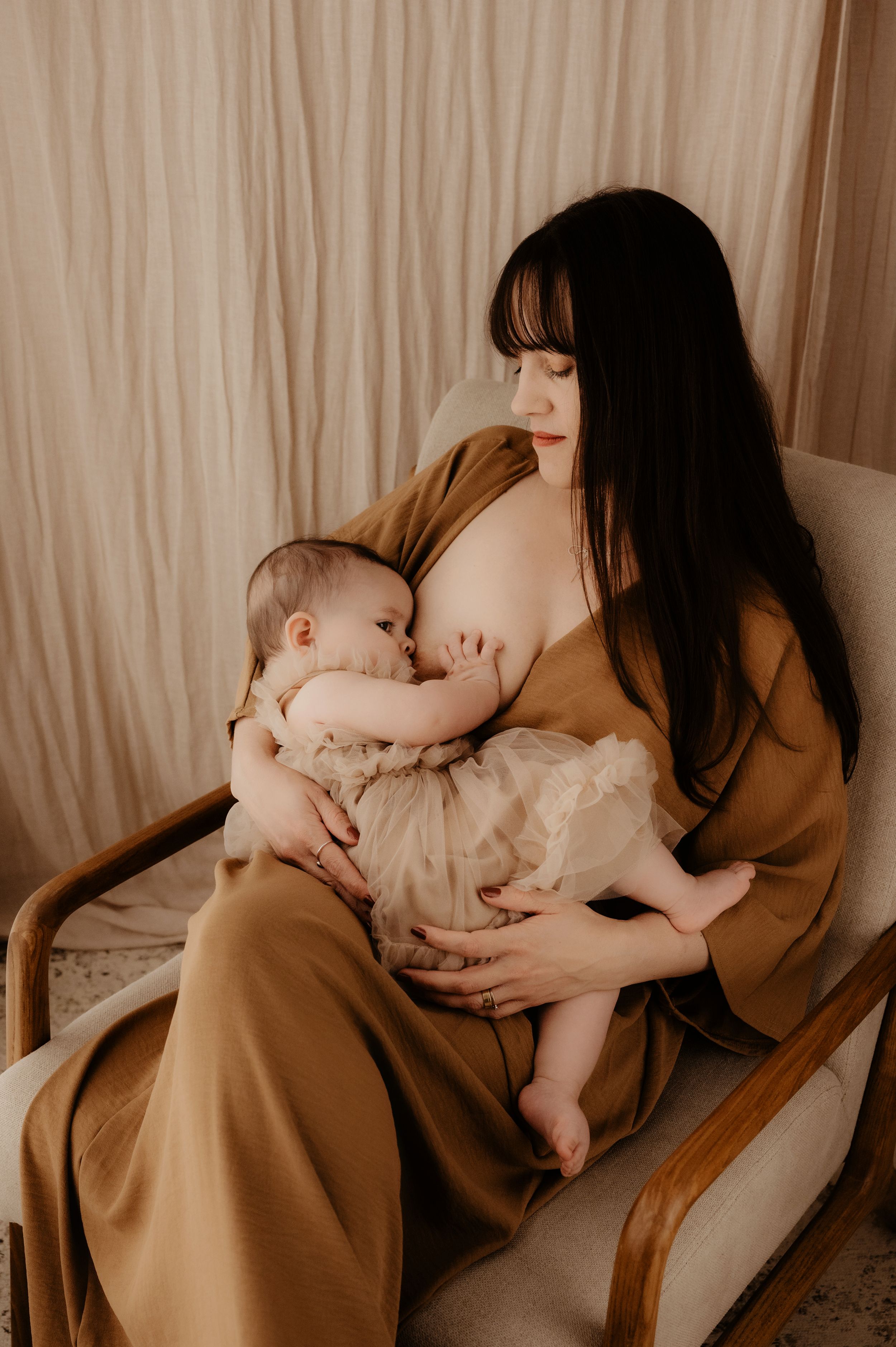 Cozy nursing session captured in warm tones showing mother and baby bonding.