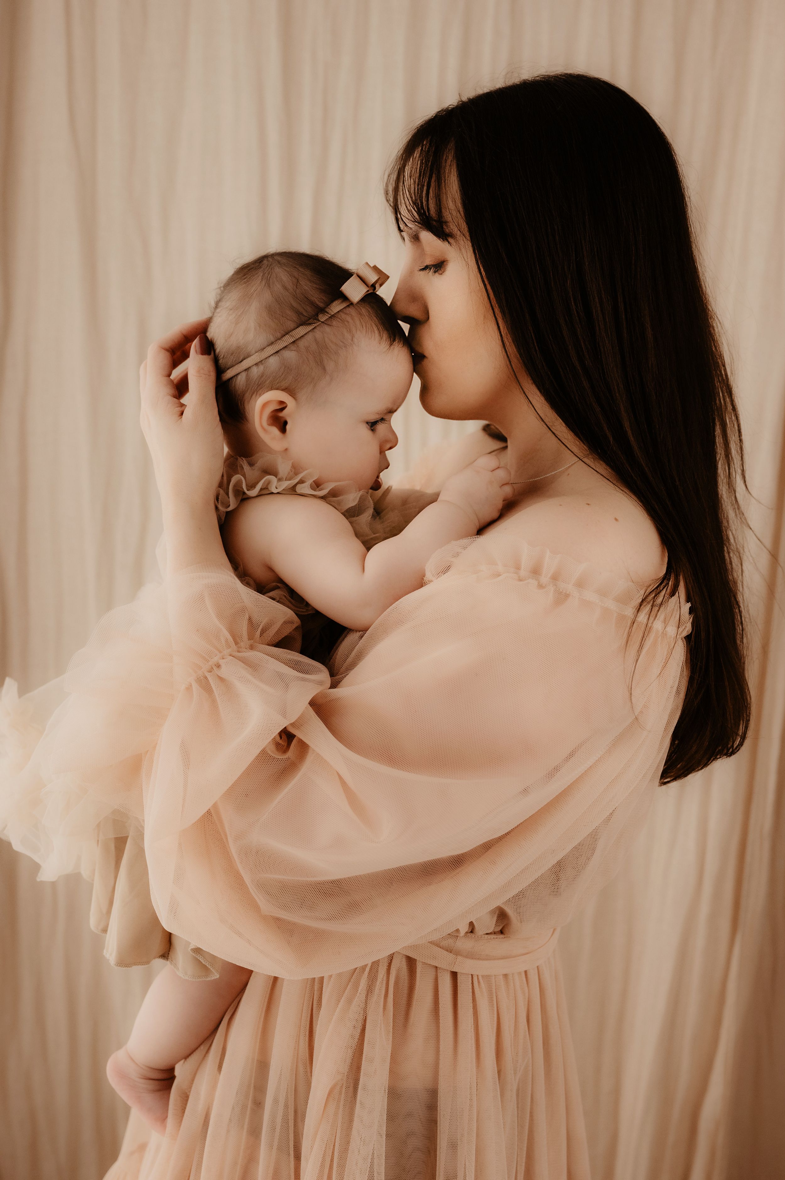 Intimate bonding moments between mother and baby in peachy flowing dresses.