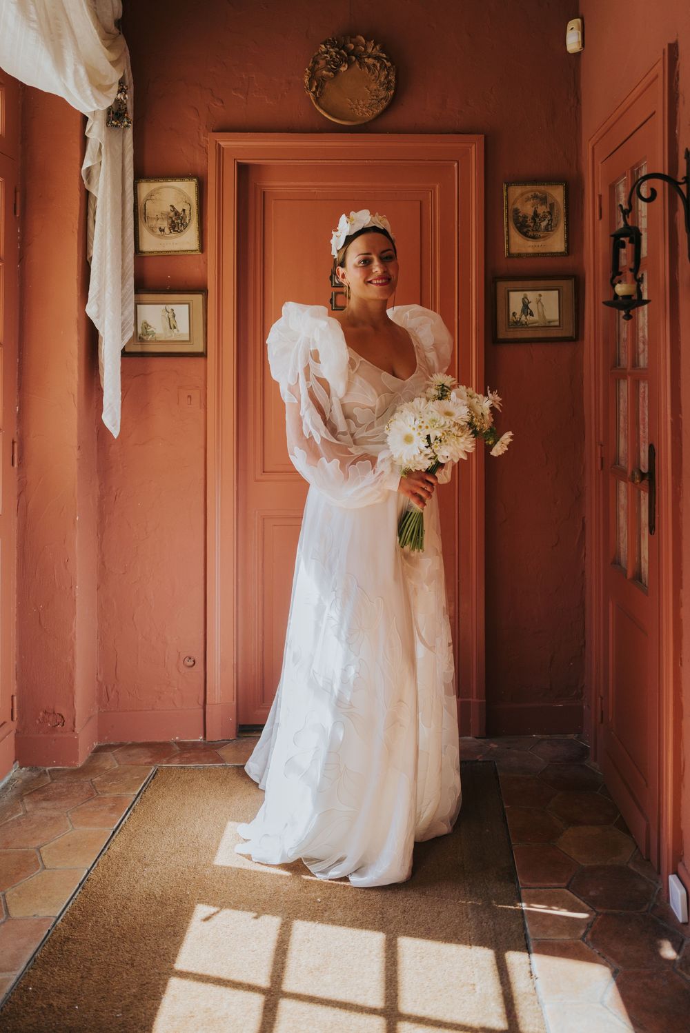A series of wedding photos showing a person in a white lace dress standing in a terracotta-colored hallway.