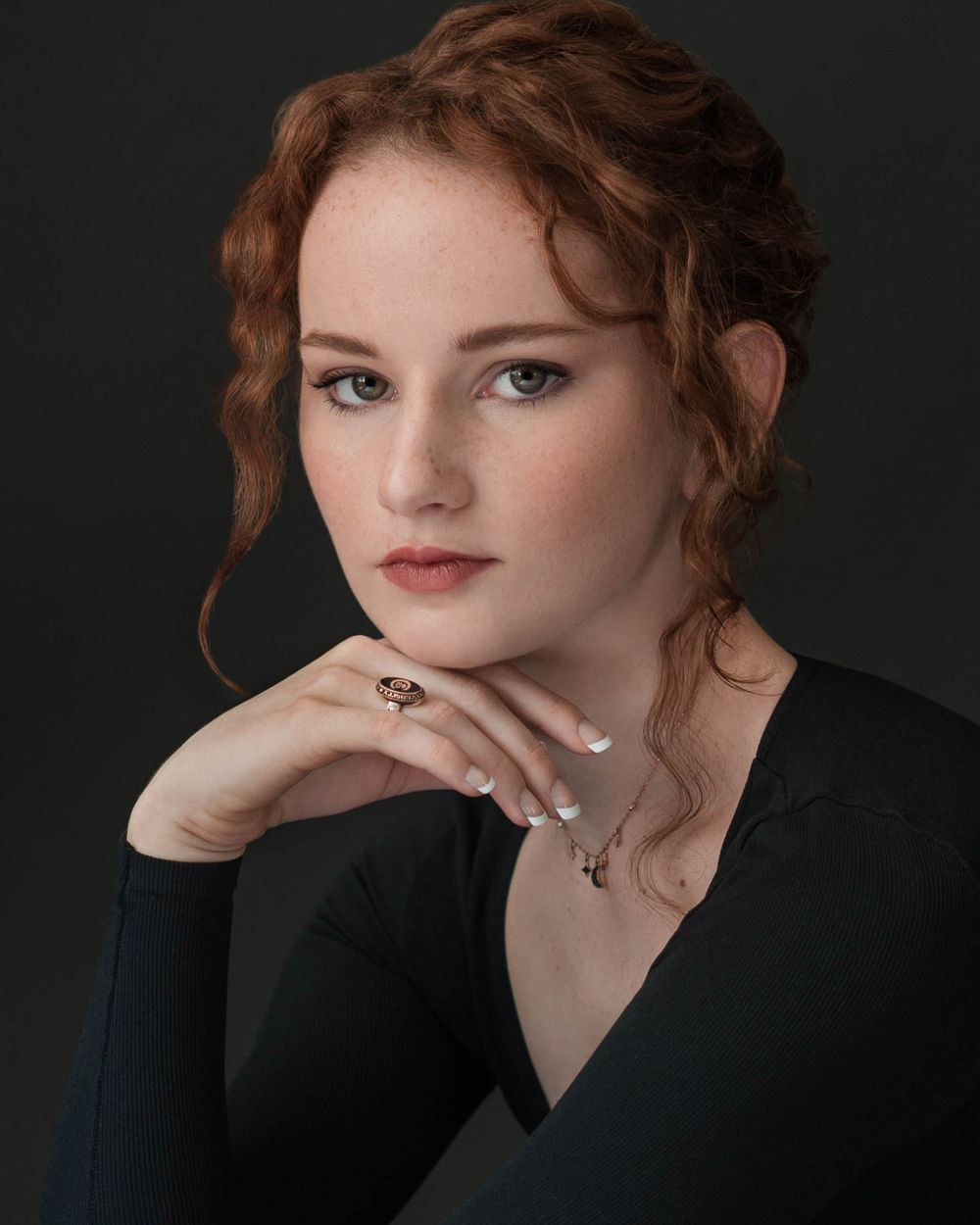 Studio college senior portrait of a graduate, with a focus on natural expressions and personal style."